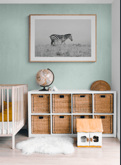 A fine art photographic print of a zebra and baby, hanging on the wall in a nursery
