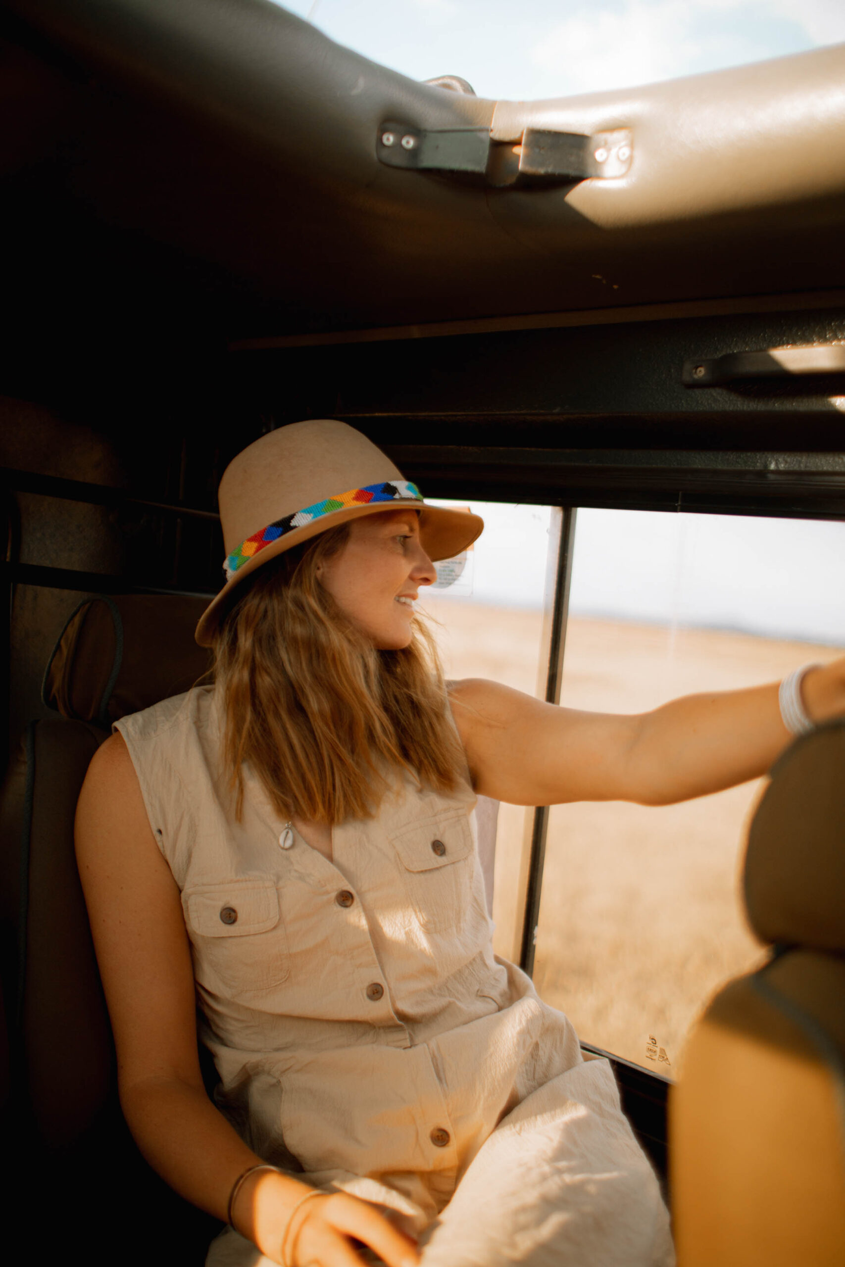 A woman looking out of a window of a safari car