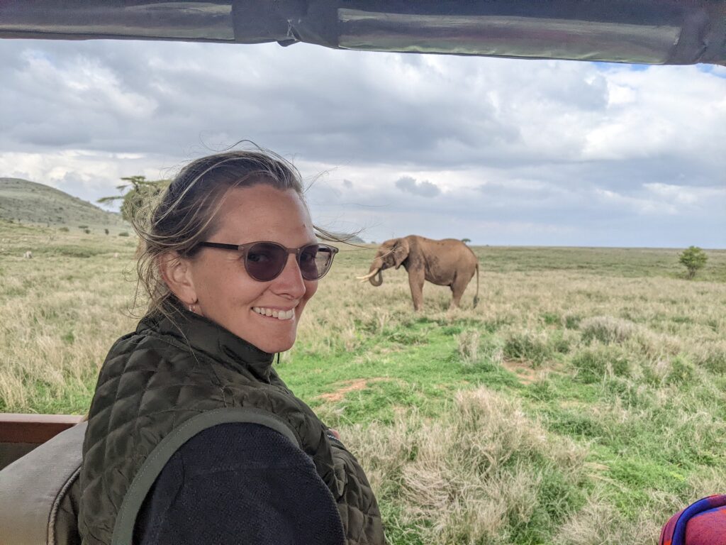 A lady on safari with an elephant behind
